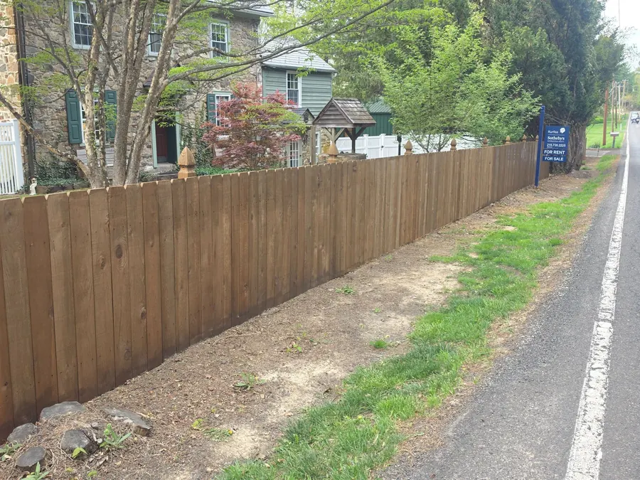 Wood privacy fence running along a road