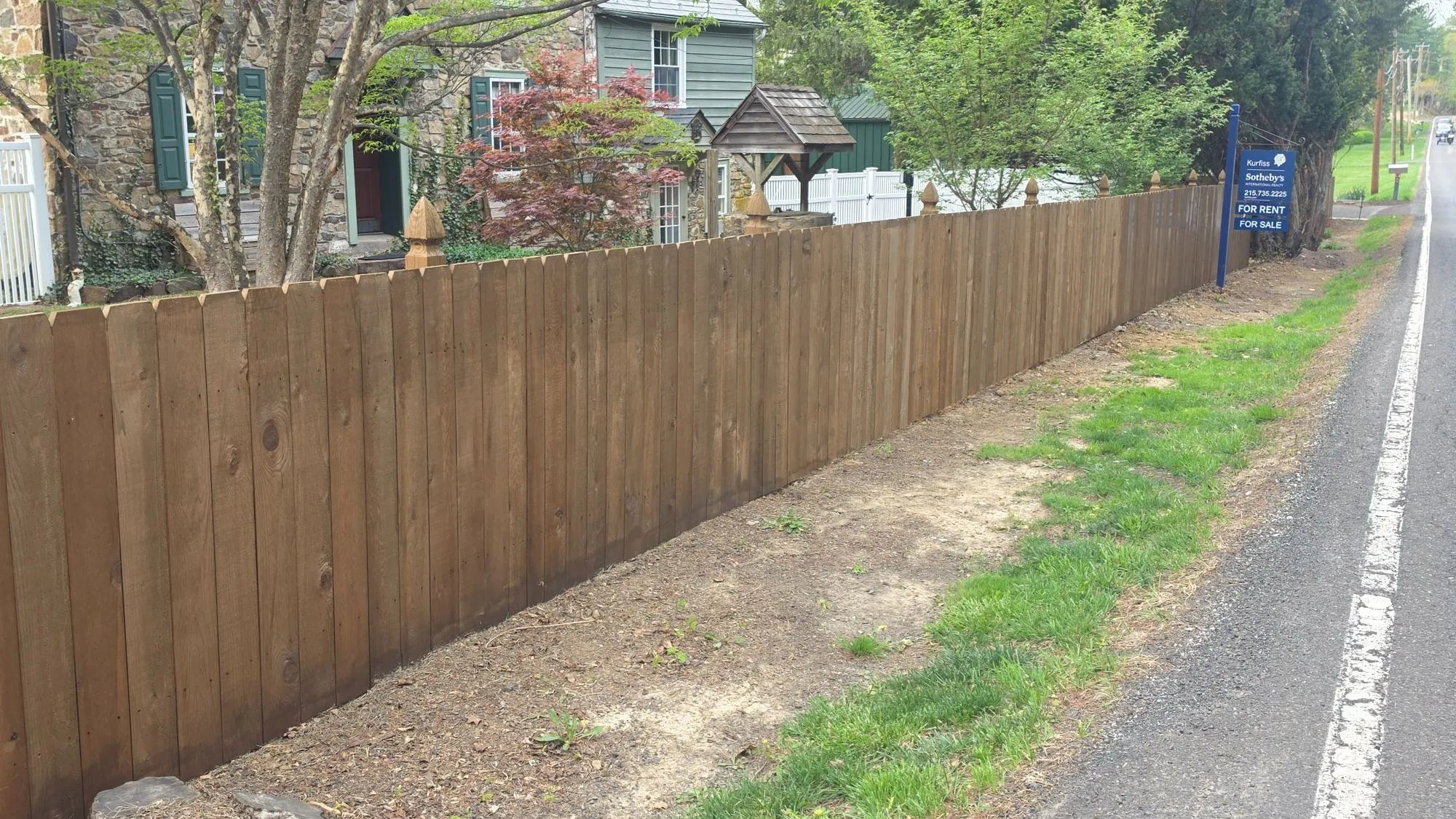 Wood privacy fence running along a road