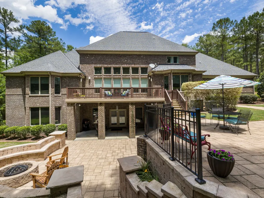 Paver patio with outdoor seating beside a landscaped yard
