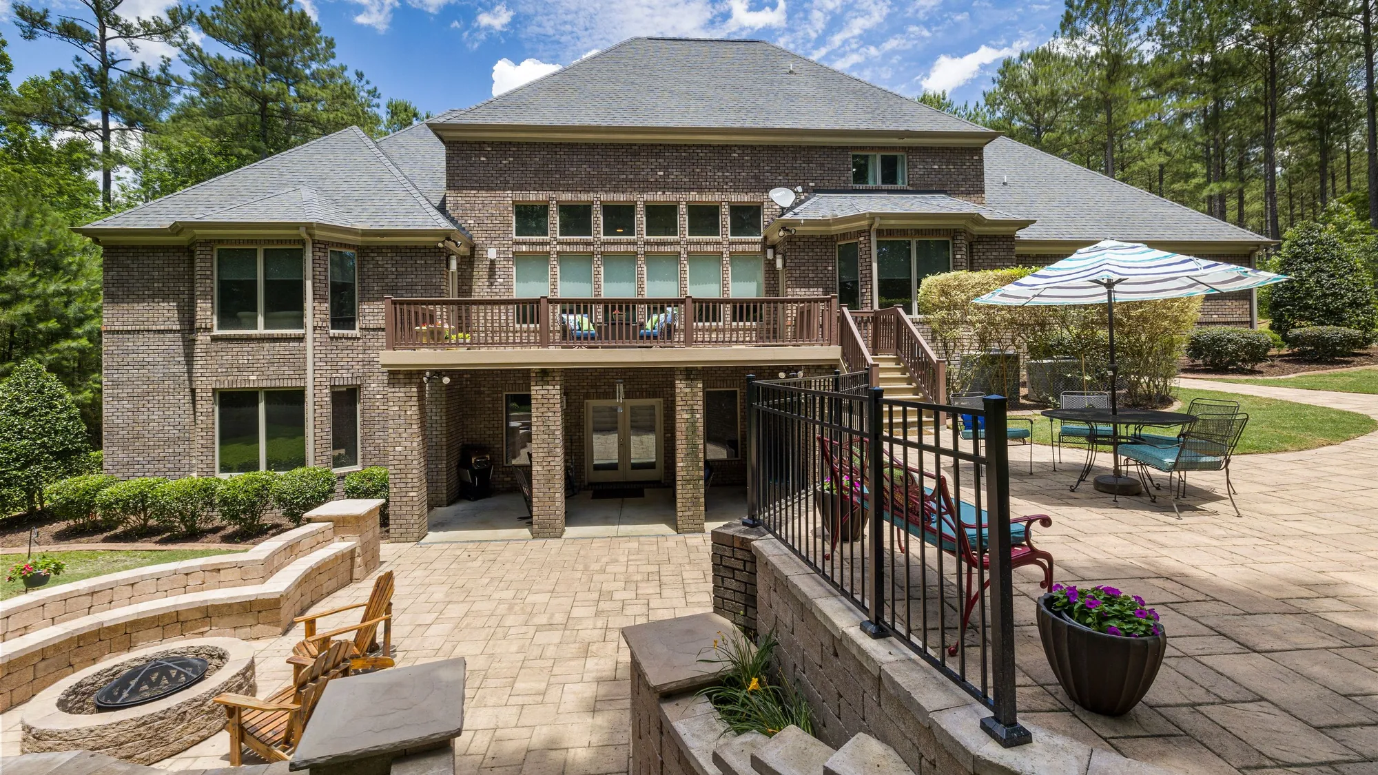 Paver patio with outdoor seating beside a landscaped yard